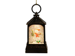 A hanging lantern Christmas ornament with a bronze finish and a glowing snowman scene inside, shown against a plain light gray wall. Text on the right reads 'Christmas Ornament Bronze Snowman 5.