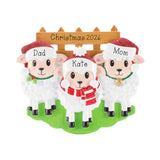 A personalized Christmas ornament featuring three sheep wearing Santa hats and scarves, with the names "Dad", "Kate", and "Mom" written on them.
