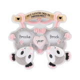 A personalized baby keepsake plaque shaped like a double-lobed clam shell with two cartoon sheep faces and a central heart. The plaque is white with pink and gray details, featuring the names 'Brooke' and 'Brock' and a heart that reads 'year°'.