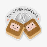 Two cute cartoon padlocks with smiling faces and blush pink cheeks, connected by silver chains, on a white backing card that says 'TOGETHER FOREVER'.