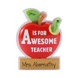 A red apple-shaped teacher gift magnet or plaque with a glittery white border. The apple features a green leaf with the word 'year' written on it, a green cartoon worm in a yellow mouth, and the text 'IS FOR AWESOME TEACHER' in white.