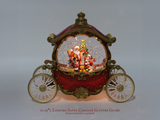 A 10.25" LED lighted Santa Claus glitter globe inside an ornate red and gold carriage, shown on a neutral gray background with a text overlay at the bottom.