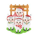 Personalized Christmas sheep family ornament featuring four white sheep labeled Mom, Lacy, Macy, and Dad under a wooden fence sign reading Christmas 2026, on a white background.