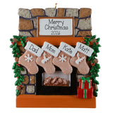 A Christmas ornament with a fireplace and stockings, each with a personalized name tag.