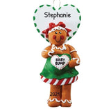 Gingerbread woman ornament with 'Baby Bump' sign and heart-shaped name tag on a white background